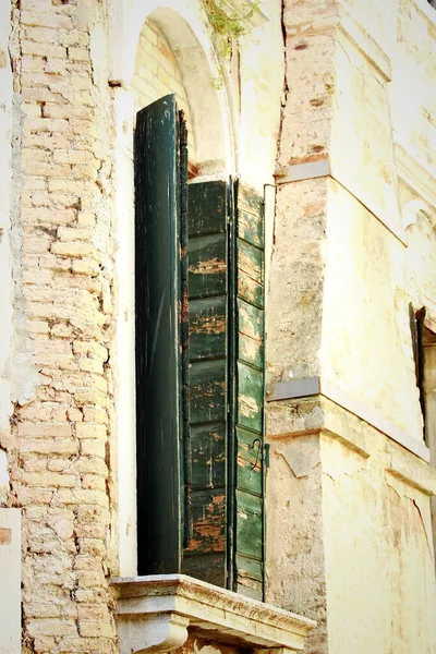 Tuğla duvardaki yeşil kepenkler