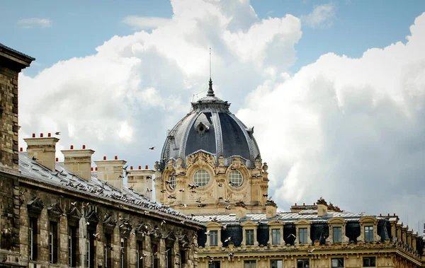 Paris 'teki antik bir binanın kubbesi Cumulus bulutlarının arka planına karşı.