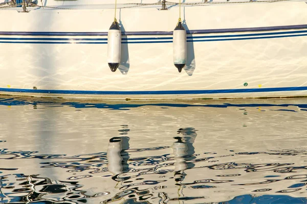 Gün batımında parlak bir yansıma yatın kenarında iskelede.