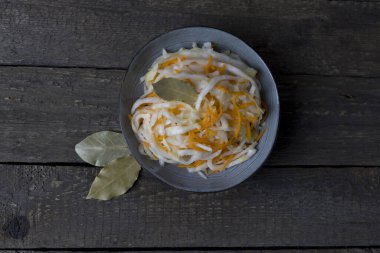 ahşap bir arka planda gri bir tabakta beyaz lahana, üst manzara