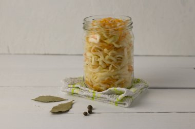 Tahta beyaz bir masada kavanozda beyaz lahana.