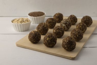 Yulaf, tohum ve fındık enerji topları beyaz bir masada.