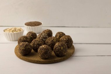 Yulaf, tohum ve fındık enerji topları beyaz bir masada.