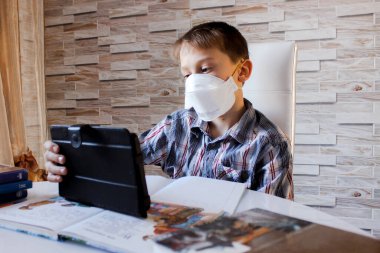 Evde online öğrenim, karantina sırasında sosyal, kendini izole etme, online eğitim konsepti, evde eğitim. Çocuk internette dil öğreniyor, dizüstü bilgisayar kullanıyor, uzaktan eğitim alıyor. Öğrenci çocuk, okul.