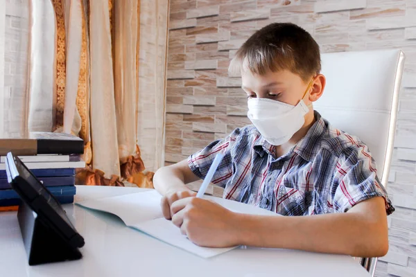 Coronavirus Covid 19 'a evde online öğrenim. Bir okul çocuğu evde okuyor ve ev ödevi yapıyor, karantina sırasındaki sosyal uzaklık, kendini soyutlama, online eğitim konsepti, ev okulu öğrencisi.