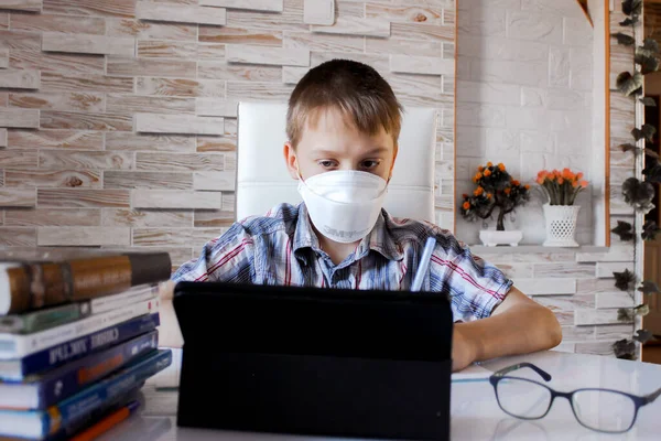Evde koronavirüs ile uzaktan öğrenme. Bir okul çocuğu evde okuyor ve ev ödevi yapıyor, karantina sırasındaki sosyal uzaklık, kendini soyutlama, online eğitim konsepti, ev okulu öğrencisi.