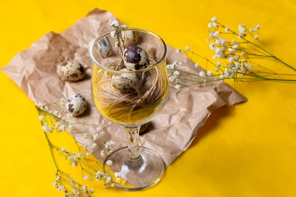 Bardakta iplikli küçük bıldırcın yumurtaları. Alışılmadık bir yemek fotoğrafı, beyaz çiçekli eski kağıt üzerindeki cam..