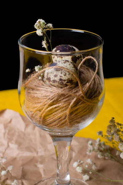 Siyah arkaplanda iplikleri ve sarı yüzeyi olan küçük bıldırcın yumurtaları. Alışılmadık bir yemek fotoğrafı, kaliteli kağıt üzerinde cam.