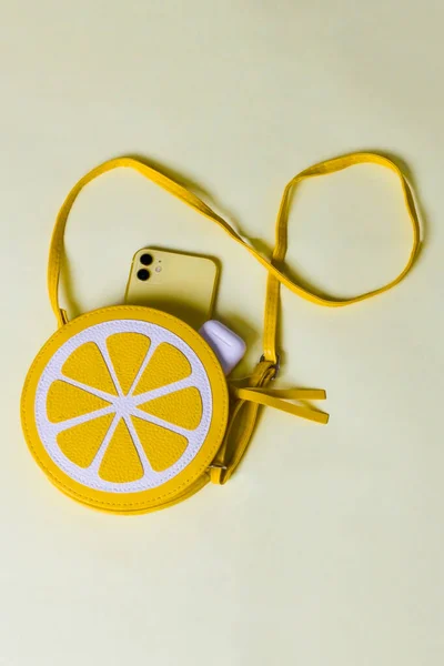 Sarı arka planda plaj aksesuarları. Güneş gözlüğü ve çizgili şapka. Yaz geliyor konsept