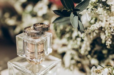 Alyanslar parfümün ve gelinin buketinin üzerinde.