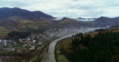 4K hava aracı görüntüleri Karpat Dağları 'nın güzel dağlık kırsal kesimi. Uzun dağ nehri, sisli sabah