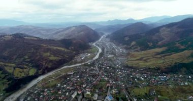 4K hava aracı görüntüleri Karpat Dağları 'nın güzel dağlık kırsal kesimi. Uzun dağ nehri, sisli sabah
