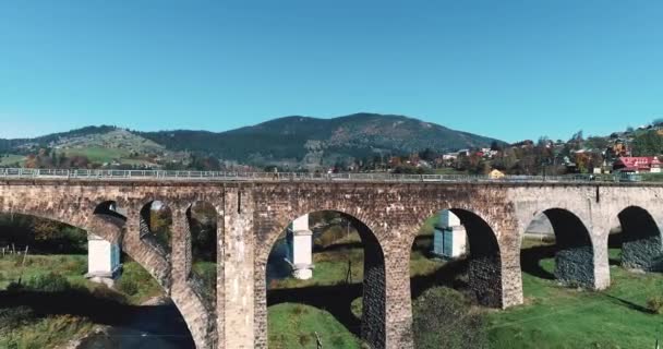在乌克兰喀尔巴阡山脉Vorokhta村的一座五彩缤纷的山下 一座田园诗般的小镇和一座铁路高架起的高架桥 从上面拍摄出了一幅美丽的风景 雄伟的风景 — 图库视频影像