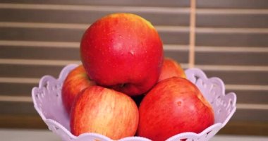 Mutfaktaki masada taze kırmızı elmalar.