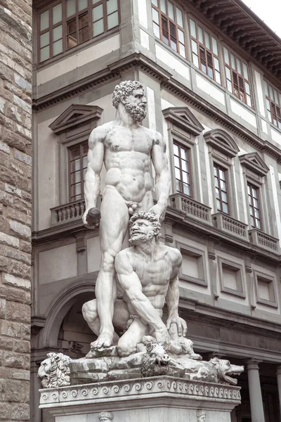 Una statua di due persone di fronte a un edificio — Foto Stock