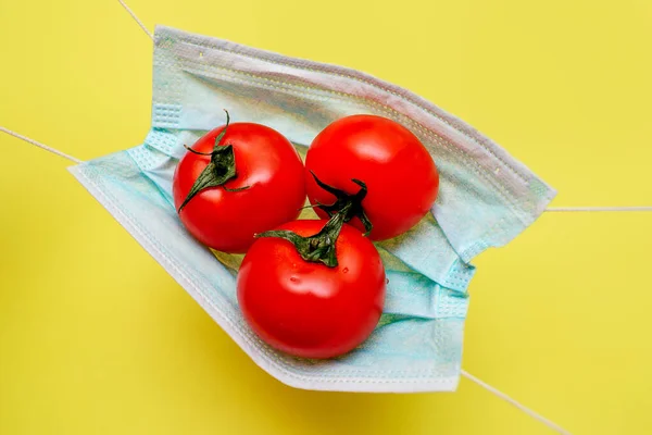 Tres Tomates Yacen Sobre Una Máscara Médica Protectora Sobre Fondo — Foto de Stock