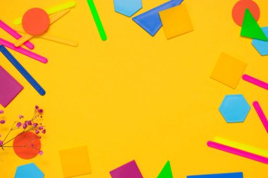 Okul konseptine geri dönelim. Düz kat. Sarı arkaplanda renk sayan çubuklar ve plastik geometrik şekiller.