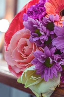 Renkli sarmal buket büyük pembe gül, beyaz amiriliz, mercan gerbera, buğday kulakları, mor karanfil ve el işi kağıdında kasımpatı.