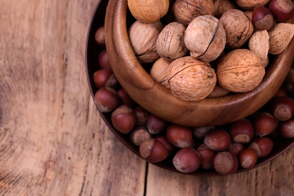 Орехи и фундук на деревенском деревянном фоне — стоковое фото