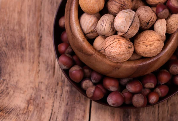 Walnuts and hazelnuts on rustic wooden background — Stock Photo, Image