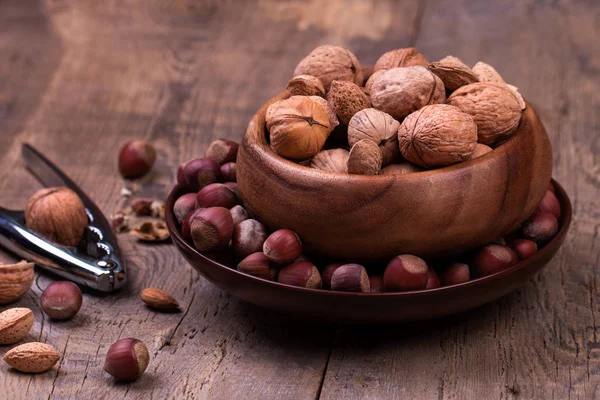 Walnuts and hazelnuts on rustic wooden background — Stock Photo, Image