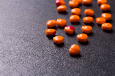 Sevgiliye arka plan. Turuncu kalp hapları veya şeker şeklinde.