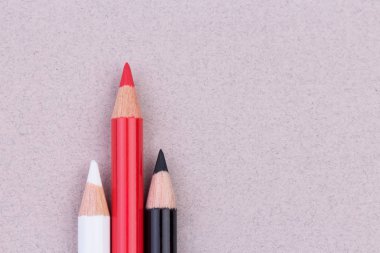 Çok renkli kalemler üzerinde bej pastel kağıt kaba doku tahıl