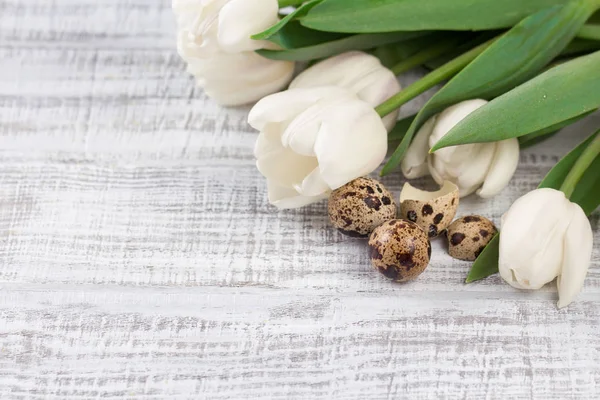 Composição de Páscoa com ovos, tulipas de primavera e coelho de porcelana na mesa de madeira velha — Fotografia de Stock