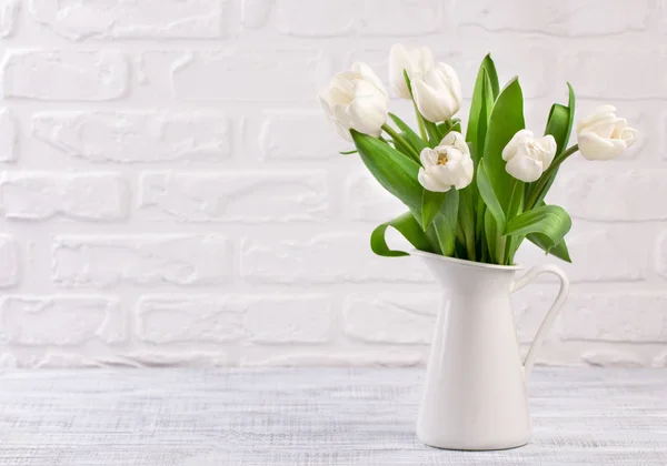 Frische weiße Tulpenblüten Bouquet vor weißer Ziegelwand. — Stockfoto