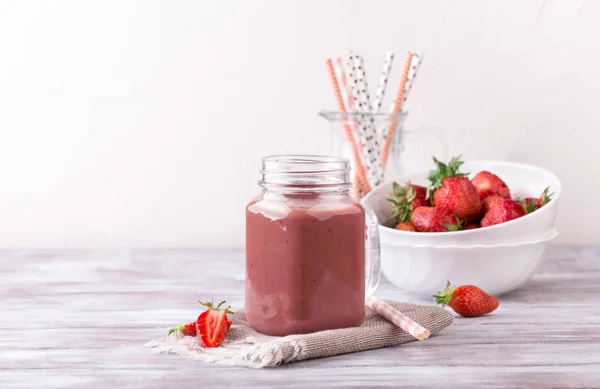 Smoothie de morango ou milkshake em jarra no fundo rústico de madeira branco — Fotografia de Stock
