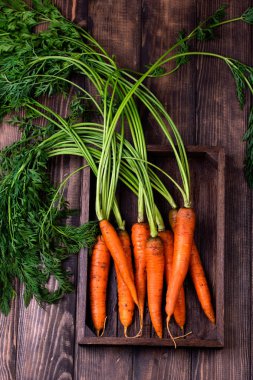 Köy ahşap arka planda taze havuçlar.