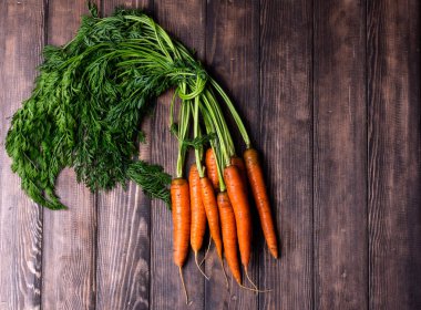 Köy ahşap arka planda taze havuçlar.