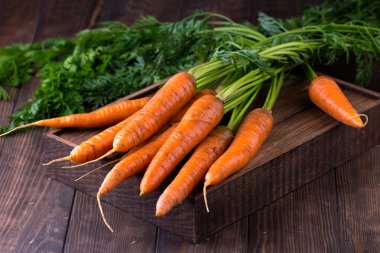 Köy ahşap arka planda taze havuçlar.