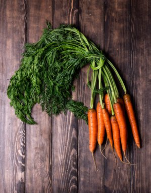 Köy ahşap arka planda taze havuçlar.