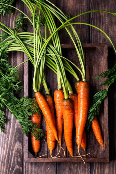 Köy ahşap arka planda taze havuçlar.