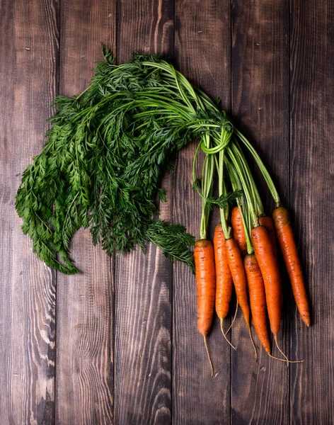 Köy ahşap arka planda taze havuçlar.