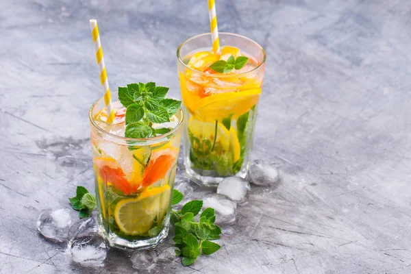 Cold refreshing summer lemonade in a glass on a grey concrete or stone background. — Stock Photo, Image