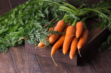 Köy ahşap arka planda taze havuçlar.