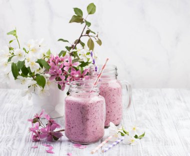 Berry güler yüzlü ya da muzlu süt beyaz ahşap rustik arka planda kavanoza