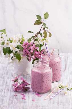 Berry güler yüzlü ya da muzlu süt beyaz ahşap rustik arka planda kavanoza