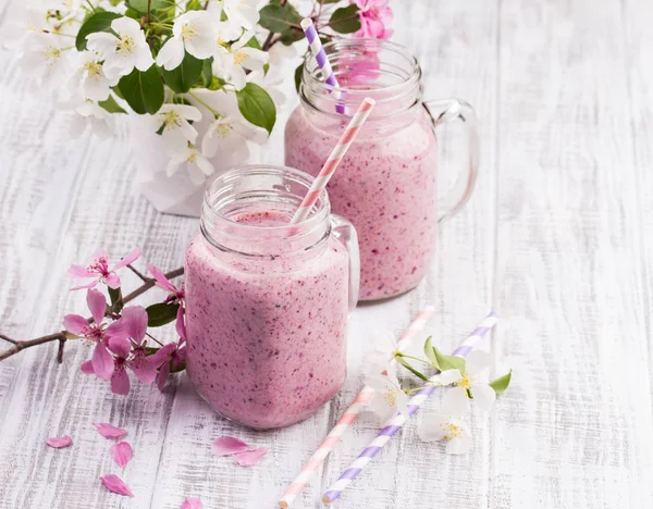 Batido de bayas o batido en frasco sobre fondo rústico de madera blanca — Foto de Stock