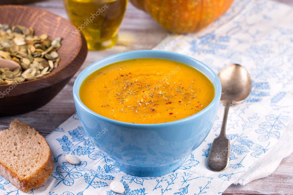 Roasted pumpkin and carrot soup with cream and pumpkin seeds