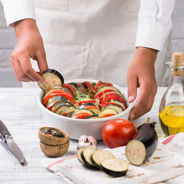 Junge Köchin bereitet Ratatouille zu. Kochen traditionelle französische Gericht - Ratatouille. — Stockfoto