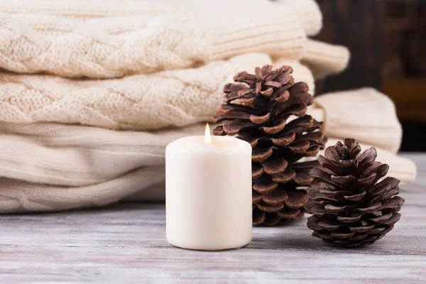 Decoração de Natal. Pilha de suéter quente, vela e cones . — Fotografia de Stock