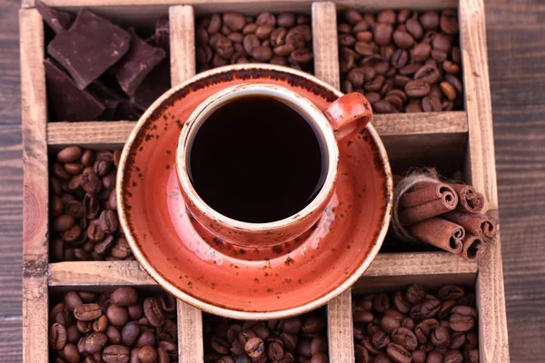 Чашку черного кофе. Старая деревянная коробка с набором кофейных зерен, темным шоколадом и корицей . — стоковое фото