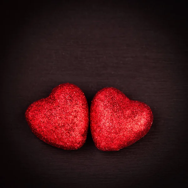 Glitter rood hartjes op een donkere achtergrond — Stockfoto