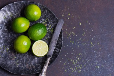 taze yeşil limes siyah çelik kase, koyu arka plan, üstten görünüm, kopya alanı