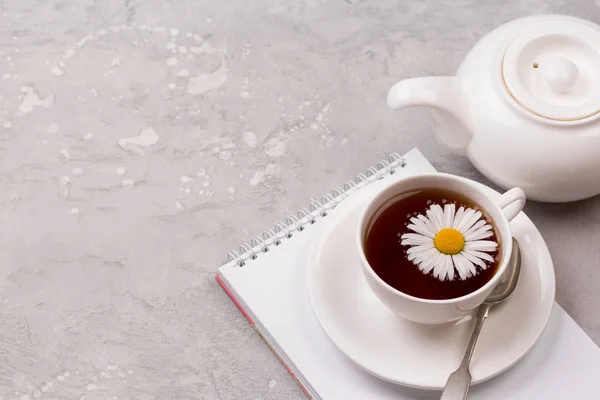 Kopje thee met kamille bloemen op grijze stenen achtergrond — Stockfoto