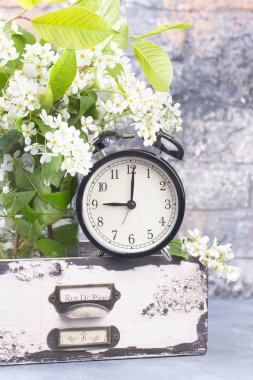 Çalar saat ile ahşap çekmece tuğla duvar arka plan bahar çiçek şube.