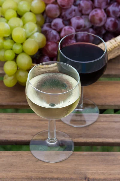 Leckeren Wein auf Holztisch auf grünem Rasen Hintergrund — Stockfoto